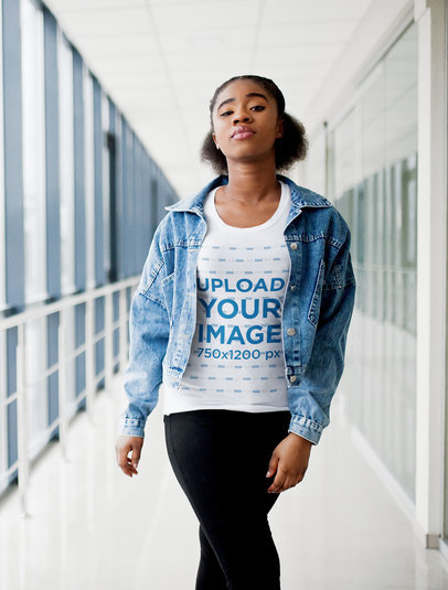 Mockup of a Woman Walking in a Hallway with a T-Shirt and a Denim Jacket