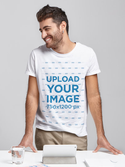 T-Shirt Mockup of a Bearded Man Standing Behind a Desk