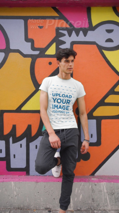 T-Shirt Video of a Man Posing in Front of a Wall with Street Art
