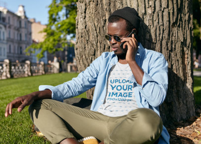 T-Shirt Mockup of a Man on the Phone at a Park