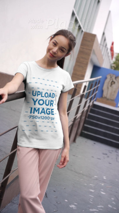 T-Shirt Video of a Young Woman Posing Outside a Building on a Cloudy Day