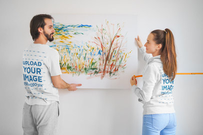 T-Shirt and Hoodie Mockup of a Couple Decorating a Wall m13054 r-el2