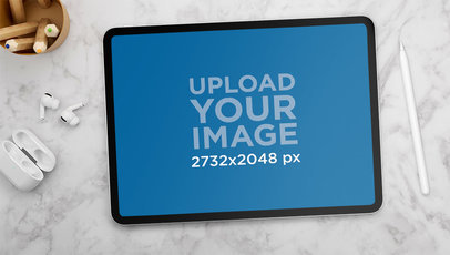 Mockup of an iPad Pro Placed Next to Some Earbuds and a Digital Pencil 