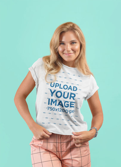 T-Shirt Mockup Featuring a Woman Posing Happily at a Studio
