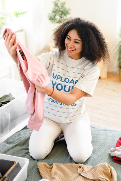 Round-Neck Tee Mockup of a Happy Woman Unfolding Clothes at Home m13058 r-el2