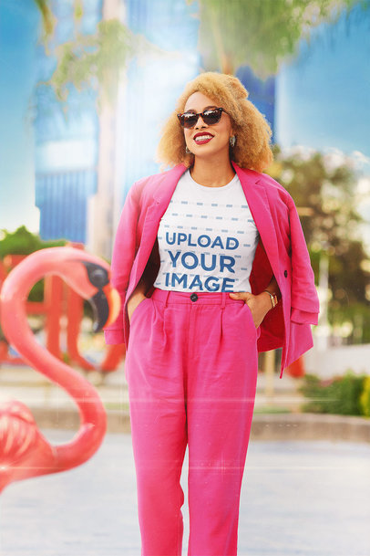 Retro-Styled T-Shirt Mockup of a Happy Woman Posing by a Flamingo Figure 