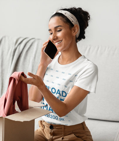 T-Shirt Mockup of a Woman Unpacking a Box While Taking on the Phone 