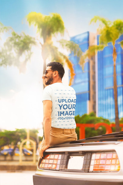 Back-View Tee Mockup of a Man Sitting on a Retro Automobile