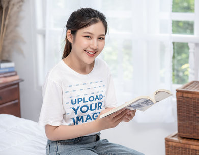 T-Shirt Mockup Featuring a Happy Woman Holding a Book
