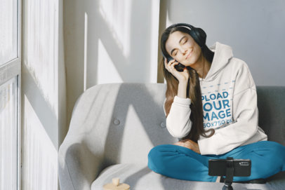 Hoodie Mockup Featuring a Smiling Woman Listening to Music