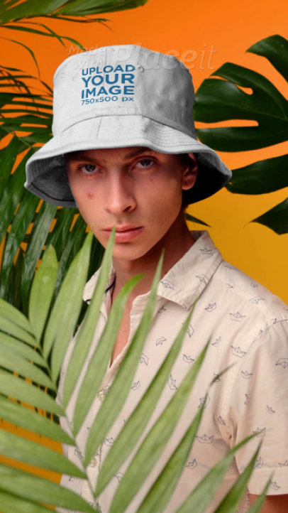 Video of a Young Man Posing with a Bucket Hat by Palm Leaves
