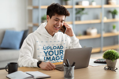 Hoodie Mockup of a Happy Young Man Working at Home 