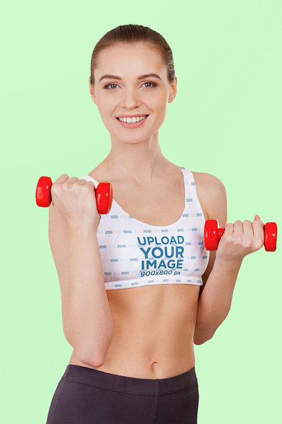 Sports Bra Mockup Featuring a Joyful Woman Lifting Weights