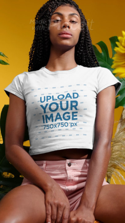 T-Shirt Video of a Serious Woman Posing by Some Palm Tree Leaves