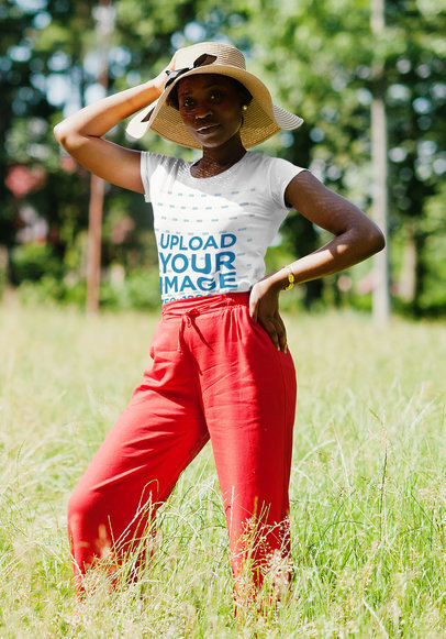 T-Shirt Mockup of a Woman in a Casual Outfit Posing on a Field
