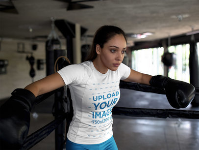 Mockup of a Tired Woman Wearing Custom Sportswear While Resting Against Ring Ropes After Sparring a16833