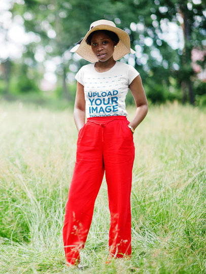 T-Shirt Mockup of a Serious Woman With a Hat Posing at a Green Grass in the Park