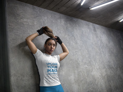Woman Wearing Custom Sportswear Mockup and Boxfit Hand Gloves While Against a Concrete Wall a16841