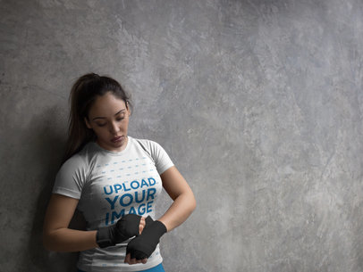 Sports Mockup of a Woman Adjusting her Boxfit Handwraps While Wearing Custom Sportswear Mockup Inside the Locker Room
