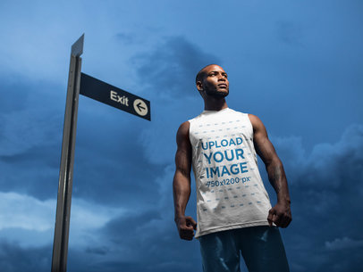 Mockup of a Man Wearing a Sleeveless Shirt Near a Sign at Night