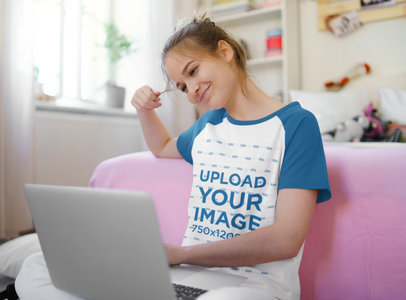 Raglan T-Shirt Mockup of a Woman Looking at Her Laptop Smiling