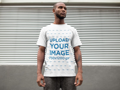 Man Wearing a Round Neck Tee Mockup While Against a Metallic Curtain a16898