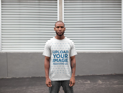 Man Wearing a T-Shirt Mockup While Standing Against Metallic Courtains a16899