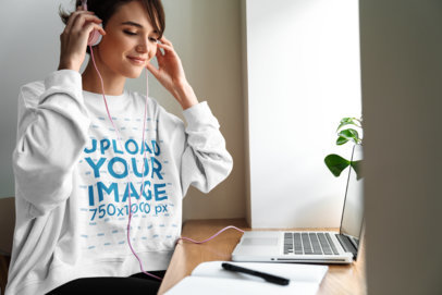 Sweatshirt Mockup of a Woman Listening to Music on Her Computer