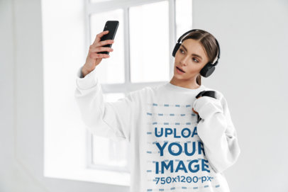 Oversize Sweatshirt Mockup of a Woman with Headphones Taking a Selfie