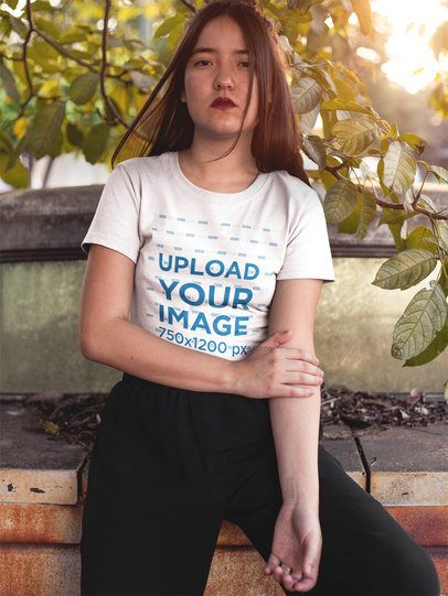 Mockup of a Serious Woman Wearing a T-Shirt While Sitting on a Park