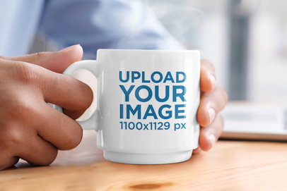 Mockup of a Person’s Hand Holding a Coffee Mug Over a Wooden Table m12837-r-el2