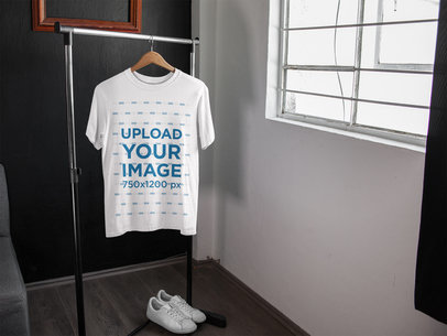 T-Shirt Mockup on a Rack Near White Shoes and a Window a16956