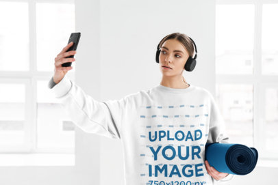 Round-Neck Sweatshirt Mockup of a Woman with Headphones Taking a Selfie