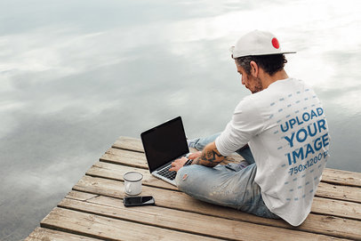 Back-View Tee Mockup of a Man with an Arm Tattoo Working Outdoors