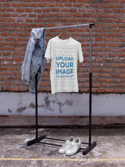 Mockup of a T-Shirt on a Hanger While Against a Bricks Wall