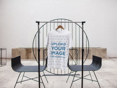 T-Shirt Mockup on a Hanger Inside a White Room