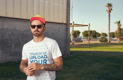 T-Shirt Mockup of a Tattooed Man Wearing Dark Sunglasses