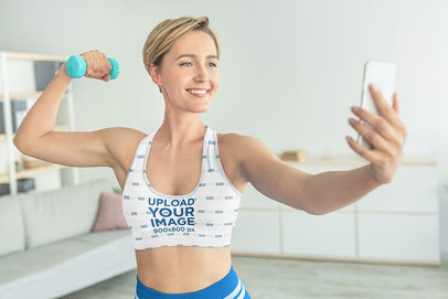 Sports Bra Mockup of a Healthy Woman Taking a Selfie with a Dumbbell