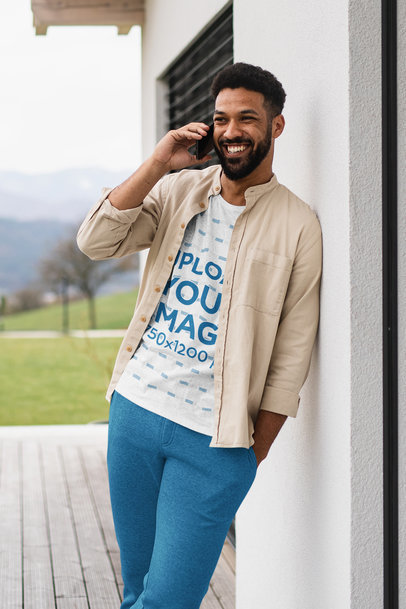 Heathered T-Shirt Mockup of a Happy Man Leaning Against a Wall and Talking on the Phone