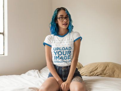 Mockup of a Woman Wearing a Ringer T-Shirt While Sitting on her Bed