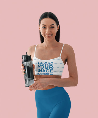Sports Bra Mockup Featuring a Smiling Fitness Woman Holding a Bottle of Water