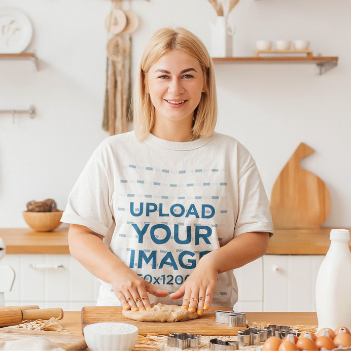Oversized T-Shirt Mockup Featuring a Happy Woman Baking at Home