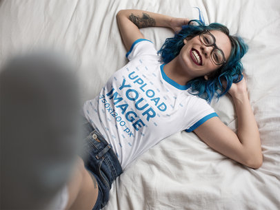Mockup of a Woman Wearing a Ringer Tshirt While Lying on a Bed