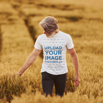 T-Shirt Mockup of an Elderly Man Walking Through a Wheat Field