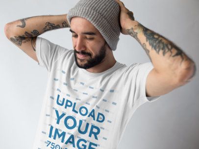 Mockup of a Man Fixing Up his Beanie While Wearing a T-Shirt at a Studio