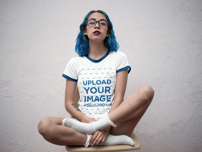 Mockup of a Hispanic Tattooed Girl Wearing a Ringer Tshirt Mockup While Sitting on a Yellow Chair a17002