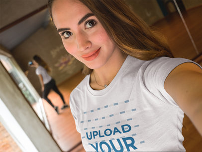 Beautiful Woman Wearing a T-Shirt Mockup While Taking a Selfie at a Dance Studio