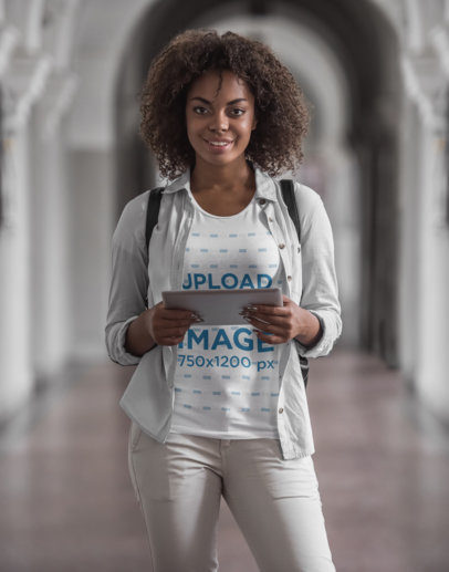 T-Shirt Mockup of a College Student Holding a Tablet