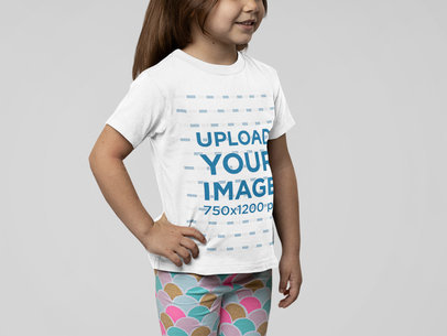 Round-Neck Tee Mockup Featuring a Little Girl Posing at a Studio