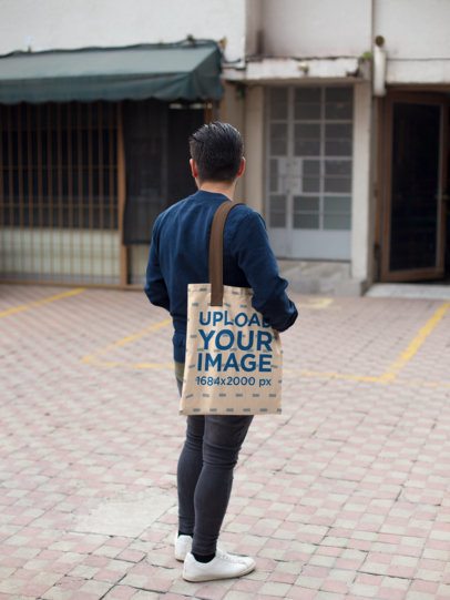 Young Man Carrying a Tote Bag Mockup from the Back